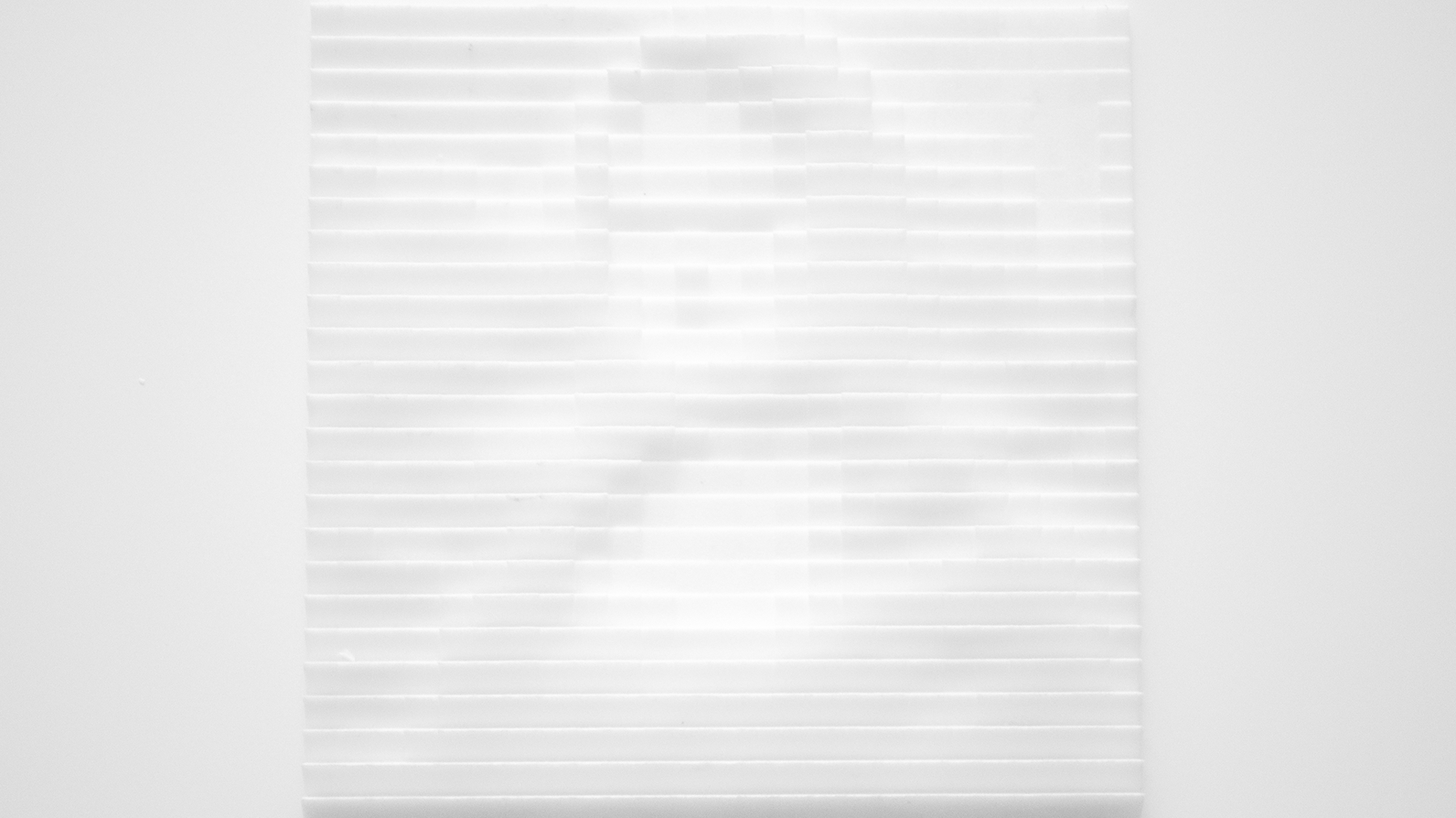 An 3d model of a white plate that has a matrix of squared surfaces all inclined differently. The different angles change the intensity of the light reflection which lead to a pixel effect. From far away it looks like the a black and white pixelated version of the mona lisa